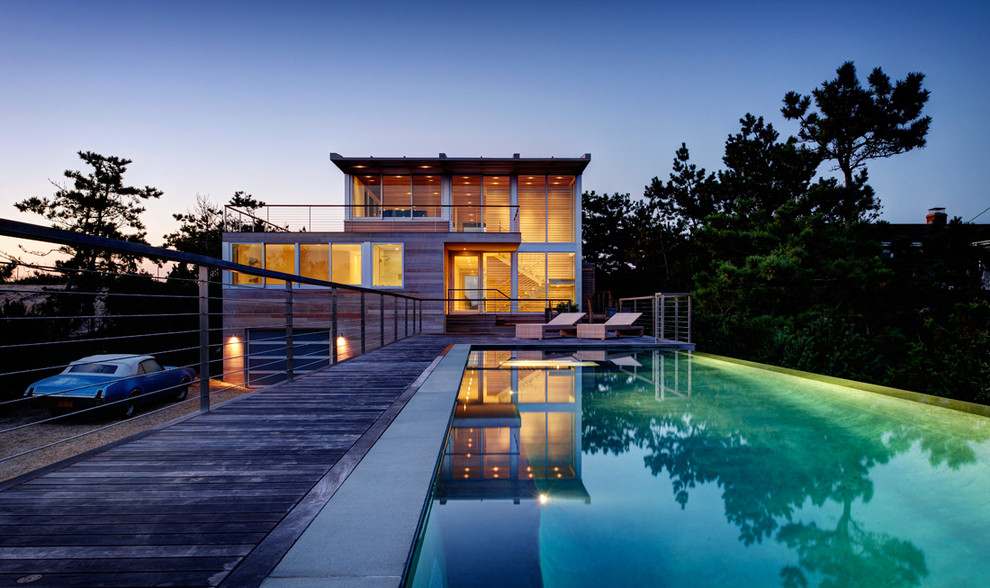 Cette photo montre une piscine moderne avec une terrasse en bois.