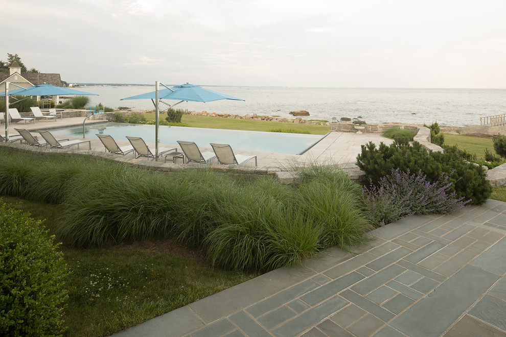 Exemple d'un très grand couloir de nage arrière moderne rectangle avec des pavés en pierre naturelle.