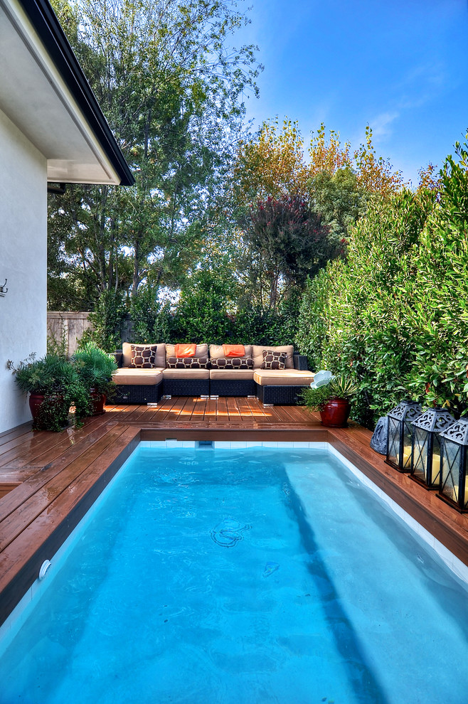 Example of a beach style pool design in Orange County with decking