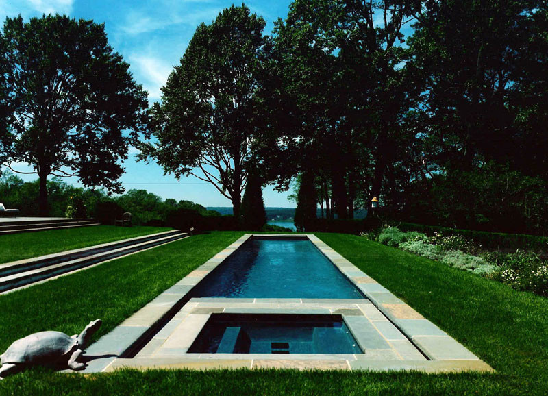 Imagen de piscinas y jacuzzis alargados contemporáneos grandes rectangulares en patio trasero con adoquines de hormigón