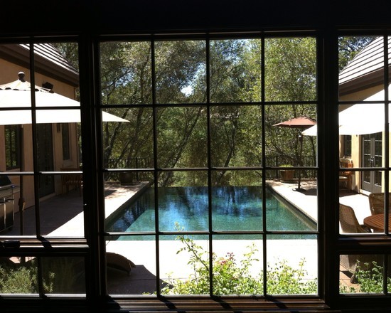 Foto de piscina infinita rústica de tamaño medio rectangular en patio con adoquines de hormigón