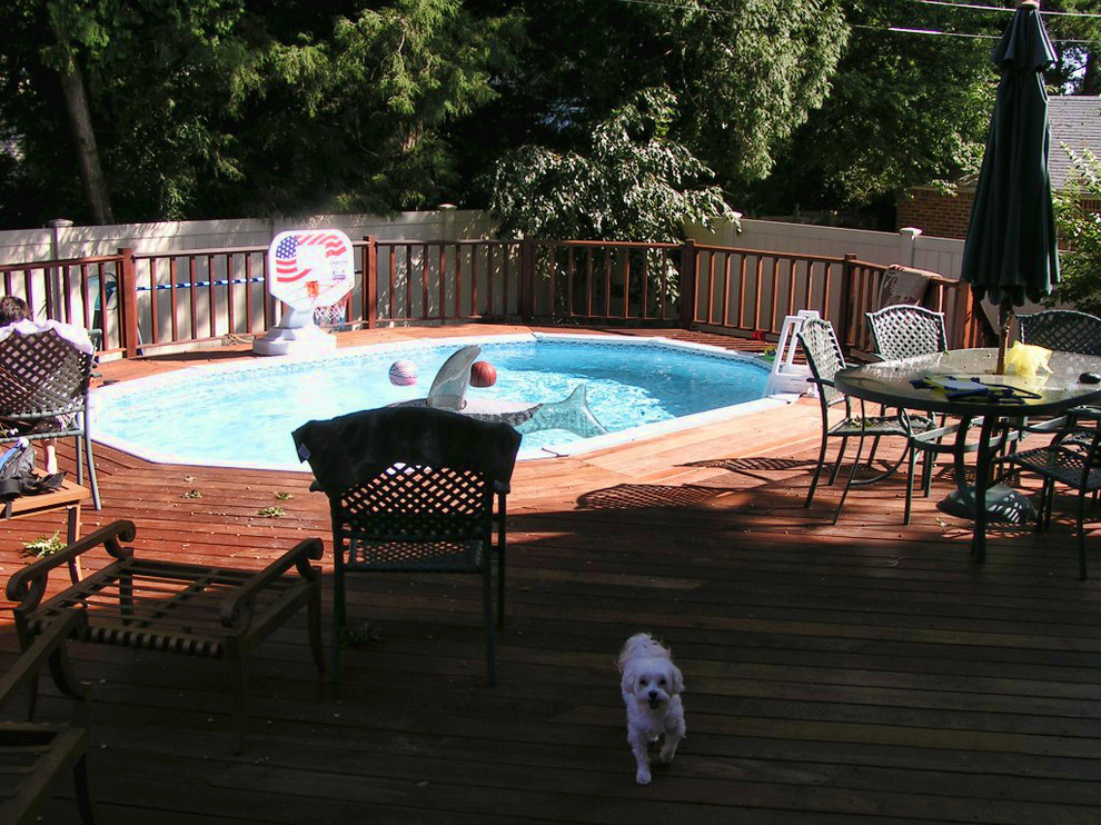 Cette photo montre une piscine arrière chic de taille moyenne et ronde avec une terrasse en bois.