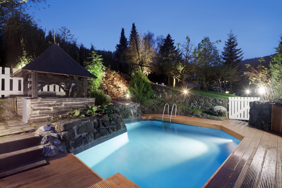 На фото: бассейн произвольной формы, среднего размера на заднем дворе в стиле рустика с фонтаном и настилом с