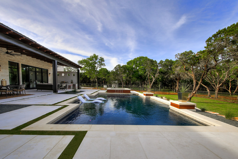 Modelo de casa de la piscina y piscina natural tradicional renovada grande rectangular en patio trasero con adoquines de piedra natural