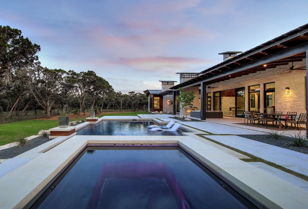 Ejemplo de casa de la piscina y piscina natural clásica renovada grande rectangular en patio trasero con adoquines de piedra natural