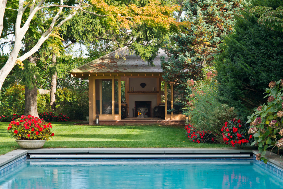 Стильный дизайн: большой прямоугольный бассейн на заднем дворе в восточном стиле с домиком у бассейна и мощением тротуарной плиткой - последний тренд