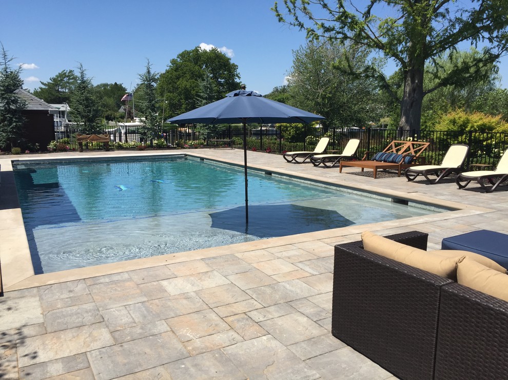 Diseño de piscina actual de tamaño medio rectangular en patio trasero