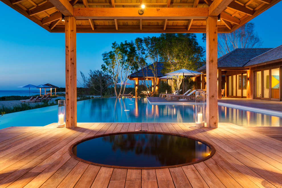Idee per una piscina tropicale rotonda dietro casa con una vasca idromassaggio