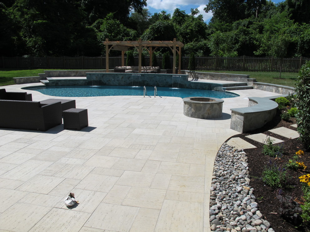 Diseño de piscina con fuente alargada tradicional grande a medida en patio trasero con adoquines de piedra natural