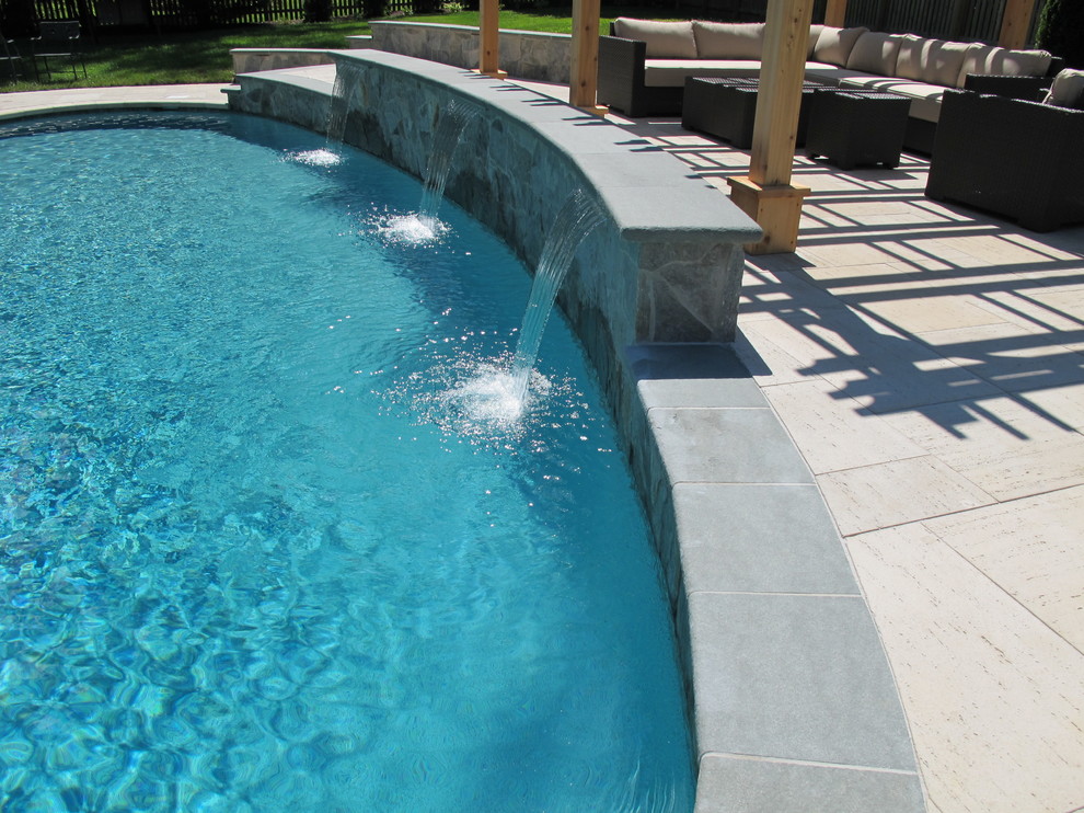 Ispirazione per una grande piscina monocorsia tradizionale personalizzata dietro casa con fontane e pavimentazioni in pietra naturale