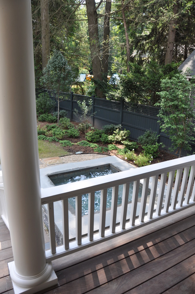 На фото: наземный, прямоугольный бассейн среднего размера на переднем дворе с джакузи с
