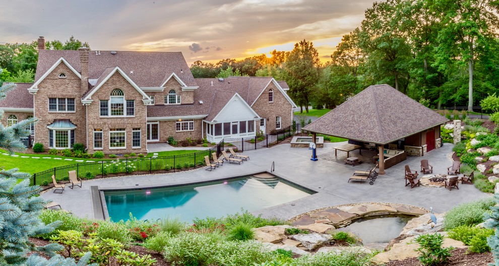 Foto de casa de la piscina y piscina clásica grande rectangular en patio trasero con suelo de hormigón estampado