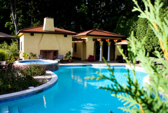 Photo of an expansive mediterranean courtyard custom shaped swimming pool in Other with a pool house.