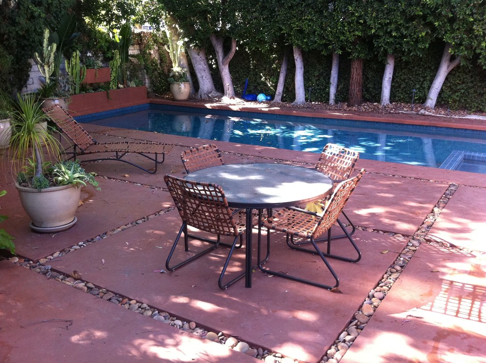 Foto de piscina actual rectangular en patio lateral con adoquines de hormigón