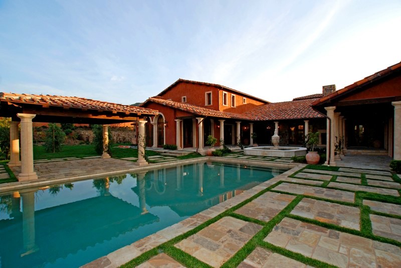 Foto di una piscina stile rurale rettangolare di medie dimensioni e dietro casa con fontane e pavimentazioni in pietra naturale