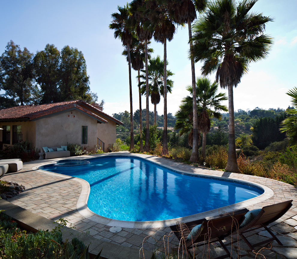 Idéer för en stor klassisk pool på baksidan av huset, med spabad och marksten i betong