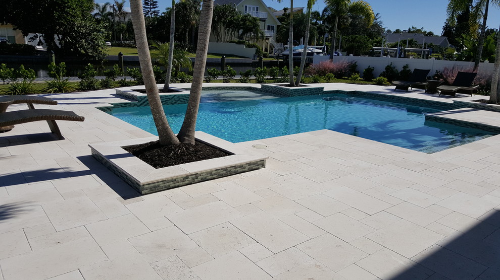 Идея дизайна: большой естественный бассейн произвольной формы на заднем дворе в современном стиле с домиком у бассейна и покрытием из каменной брусчатки
