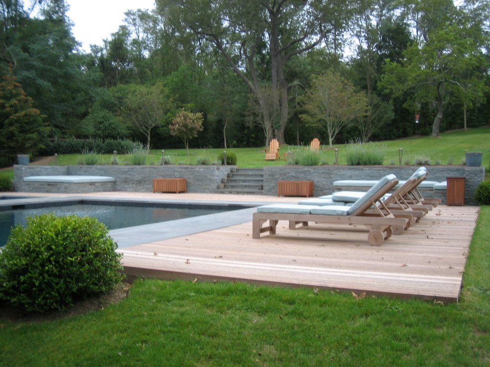Photo of a large bohemian back rectangular infinity hot tub in New York with decking.