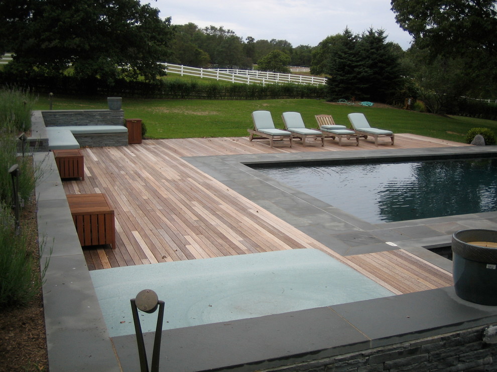 Diseño de piscinas y jacuzzis infinitos bohemios grandes rectangulares en patio trasero con entablado