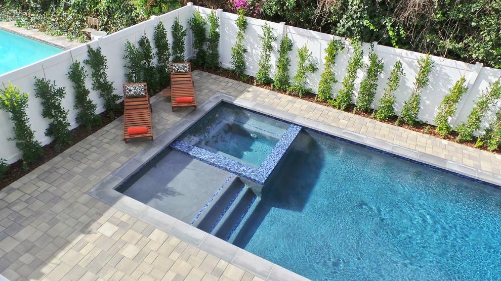 Idéer för en mellanstor modern pool på baksidan av huset, med spabad och marksten i betong