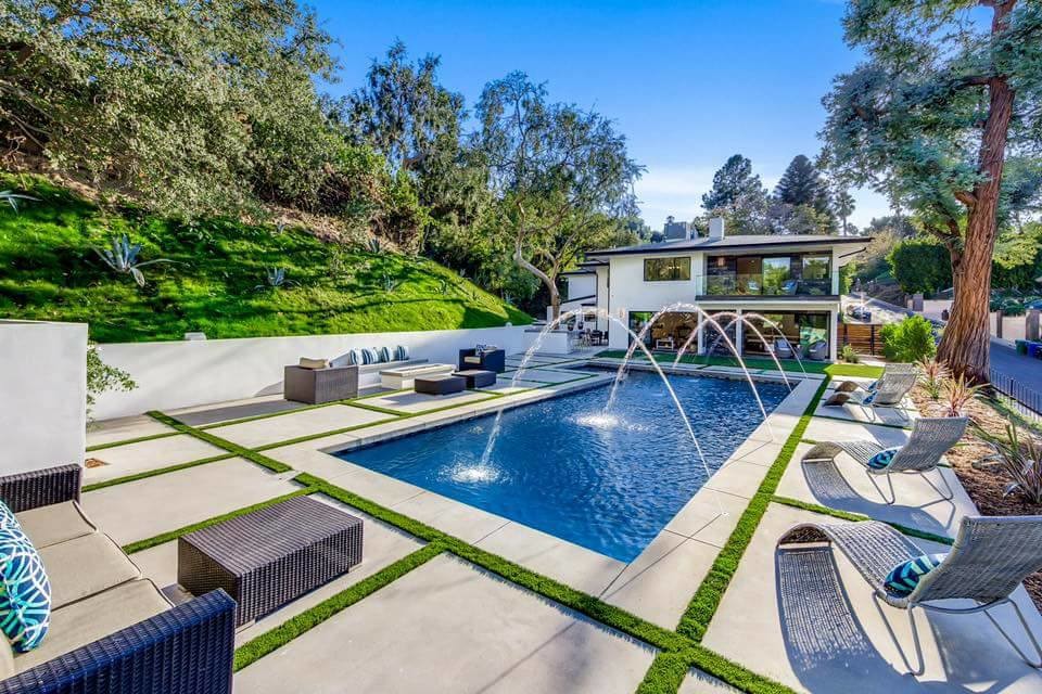 Großes Modernes Sportbecken hinter dem Haus in rechteckiger Form mit Wasserspiel und Betonboden in Los Angeles