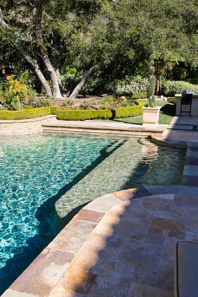 Esempio di una piscina naturale mediterranea rettangolare di medie dimensioni e dietro casa con una vasca idromassaggio e piastrelle