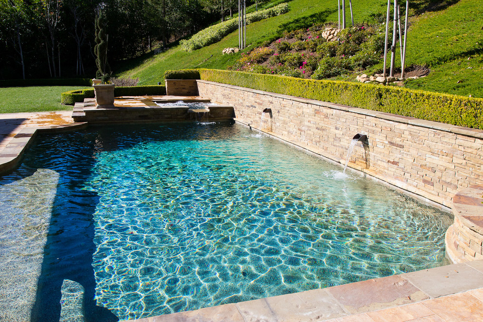 Ispirazione per una piscina naturale mediterranea rettangolare di medie dimensioni e dietro casa con una vasca idromassaggio e piastrelle