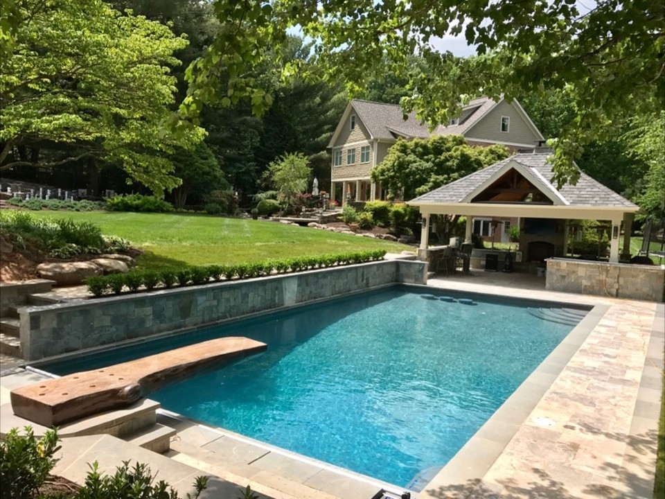 Imagen de casa de la piscina y piscina alargada clásica de tamaño medio rectangular en patio trasero con suelo de baldosas