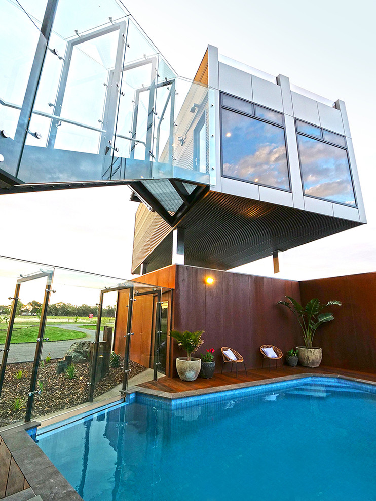 Idée de décoration pour une piscine arrière minimaliste rectangle avec une terrasse en bois.