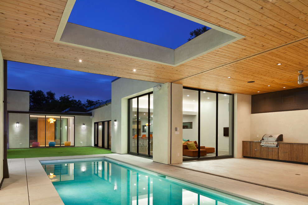 Стильный дизайн: прямоугольный бассейн на заднем дворе в современном стиле с покрытием из каменной брусчатки - последний тренд