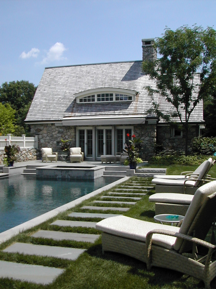 Exemple d'une piscine chic rectangle avec des pavés en pierre naturelle.
