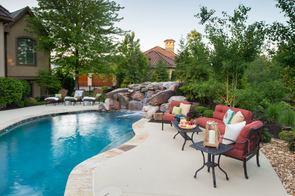 Diseño de piscinas y jacuzzis naturales rústicos redondeados en patio trasero con adoquines de piedra natural