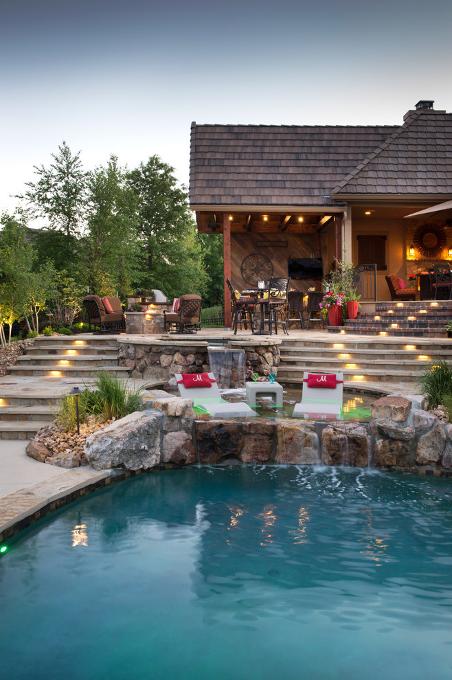 Example of a mountain style backyard stone and round natural hot tub design in Kansas City