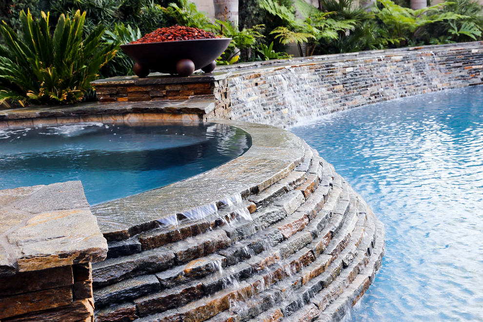 Diseño de piscina con fuente alargada clásica de tamaño medio tipo riñón en patio trasero