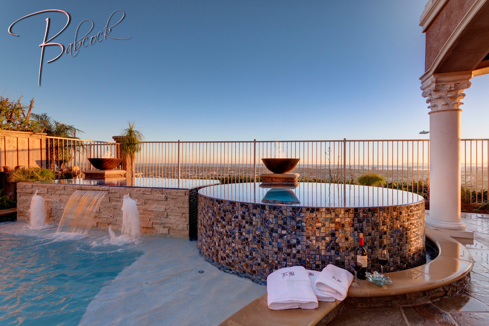 Immagine di una piscina a sfioro infinito mediterranea personalizzata dietro casa