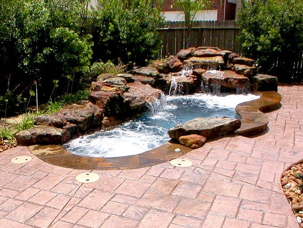 Large elegant backyard stamped concrete and custom-shaped natural pool fountain photo in Houston
