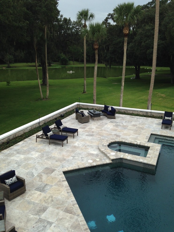 На фото: большой спортивный бассейн в форме фасоли на заднем дворе в морском стиле с покрытием из каменной брусчатки