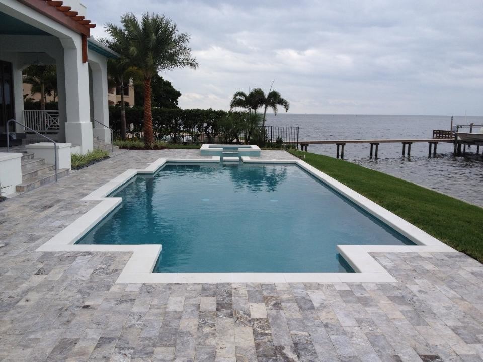 Esempio di una piscina monocorsia moderna personalizzata di medie dimensioni e in cortile con fontane e pavimentazioni in pietra naturale
