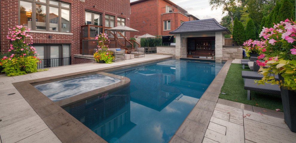 Photo of a large modern back rectangular swimming pool in Other with a water feature and natural stone paving.
