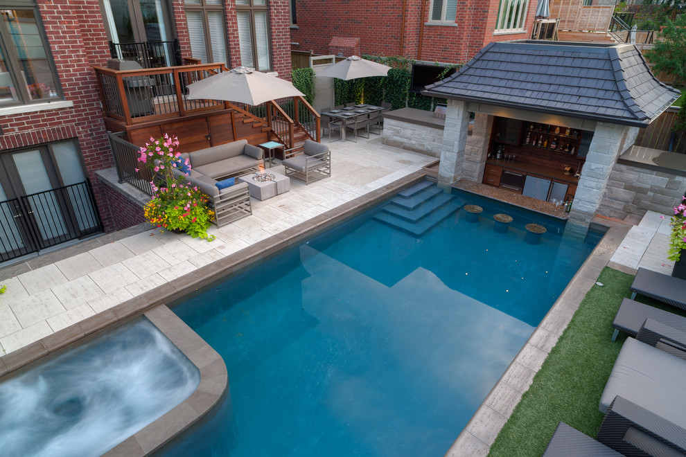 Photo of a large modern back rectangular swimming pool in Other with a water feature and natural stone paving.