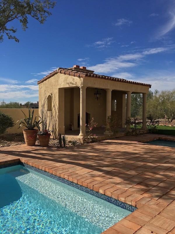 Modelo de casa de la piscina y piscina mediterránea grande rectangular en patio trasero con adoquines de ladrillo