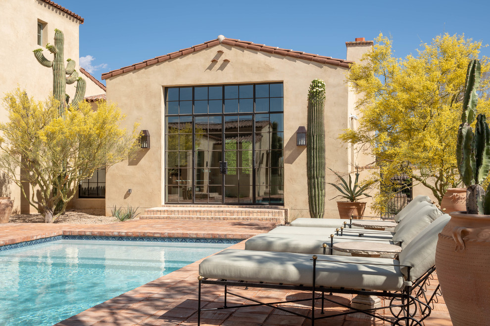 Pool house - large mediterranean backyard brick and rectangular pool house idea in Phoenix