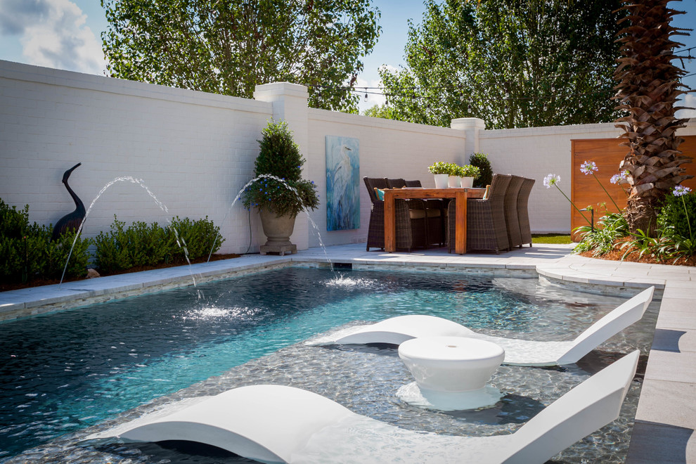 Imagen de piscina con fuente alargada contemporánea de tamaño medio a medida en patio trasero con adoquines de hormigón