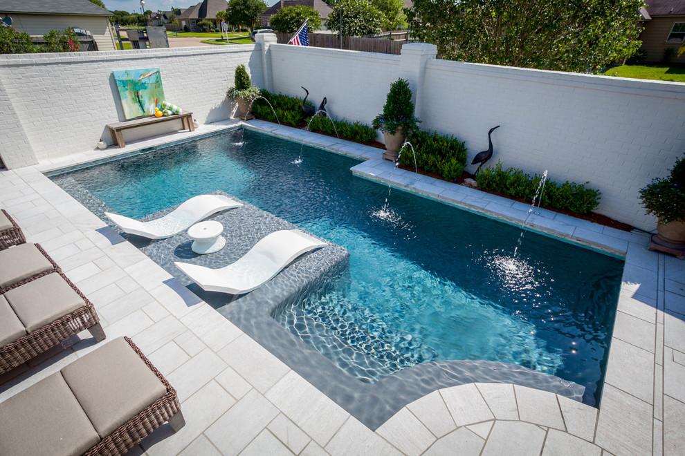 Foto di una piscina monocorsia minimal personalizzata di medie dimensioni e dietro casa con fontane e pavimentazioni in cemento