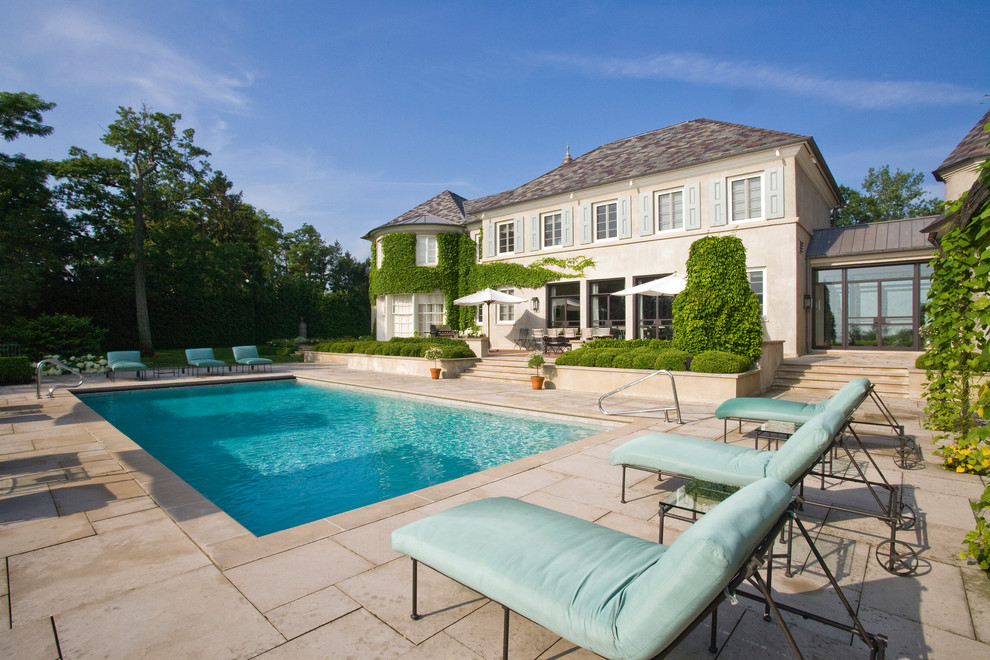 Imagen de piscina de estilo de casa de campo grande rectangular en patio trasero con adoquines de hormigón