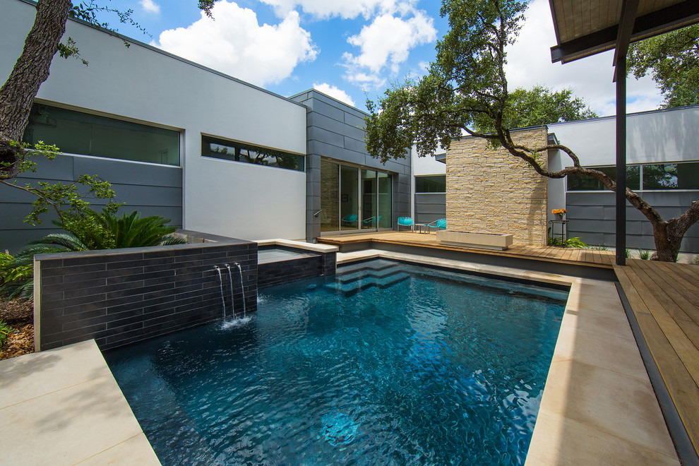 Small modern courtyard rectangular lengths hot tub in Austin with natural stone paving.