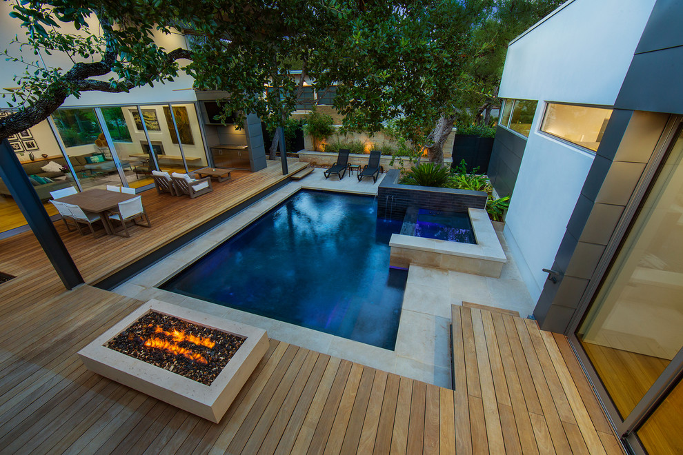 Foto di una piccola piscina monocorsia moderna rettangolare in cortile con una vasca idromassaggio e pavimentazioni in pietra naturale