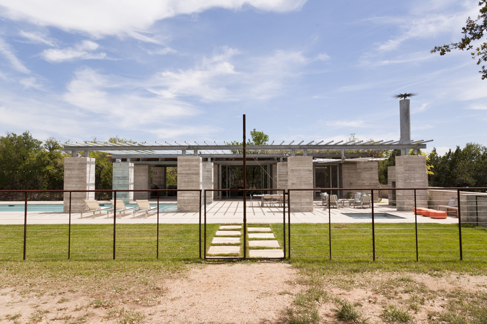 Foto di una piscina monocorsia contemporanea rettangolare di medie dimensioni e dietro casa con una dépendance a bordo piscina e lastre di cemento