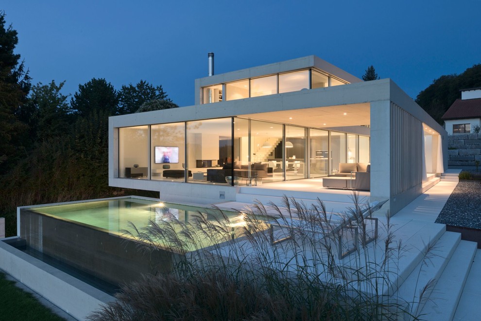 Geräumiger Moderner Infinity-Pool hinter dem Haus in rechteckiger Form mit Betonplatten in Orlando