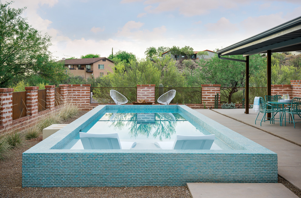Immagine di una piccola piscina american style rettangolare dietro casa con lastre di cemento